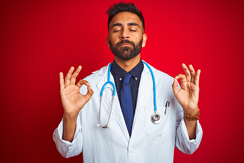 young male doctor wearing stethoscope standing over red background relaxed smiling with eyes closed doing meditation gesture with fingers - life is peaceful when you use Joy Pilot